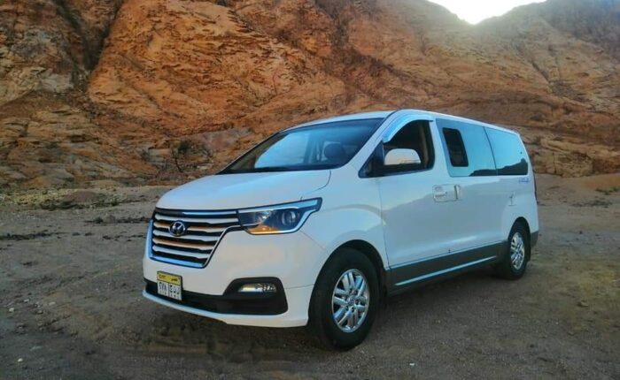 Air-conditioned tour transportation parked at an Egyptian historic site, offering convenient travel for tourists.