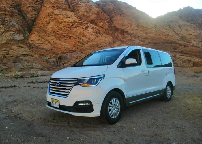 Air-conditioned tour transportation parked at an Egyptian historic site, offering convenient travel for tourists.